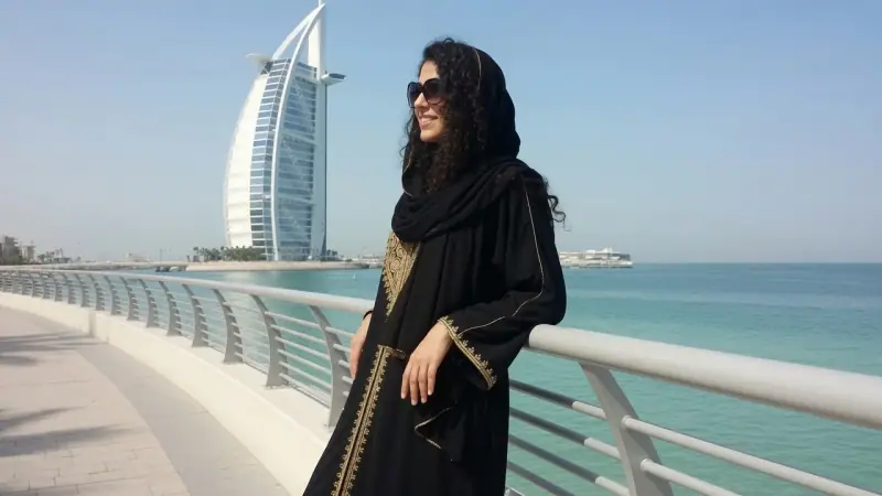 Maya Carter by the Dubai waterfront, the Burj Al Arab behind her